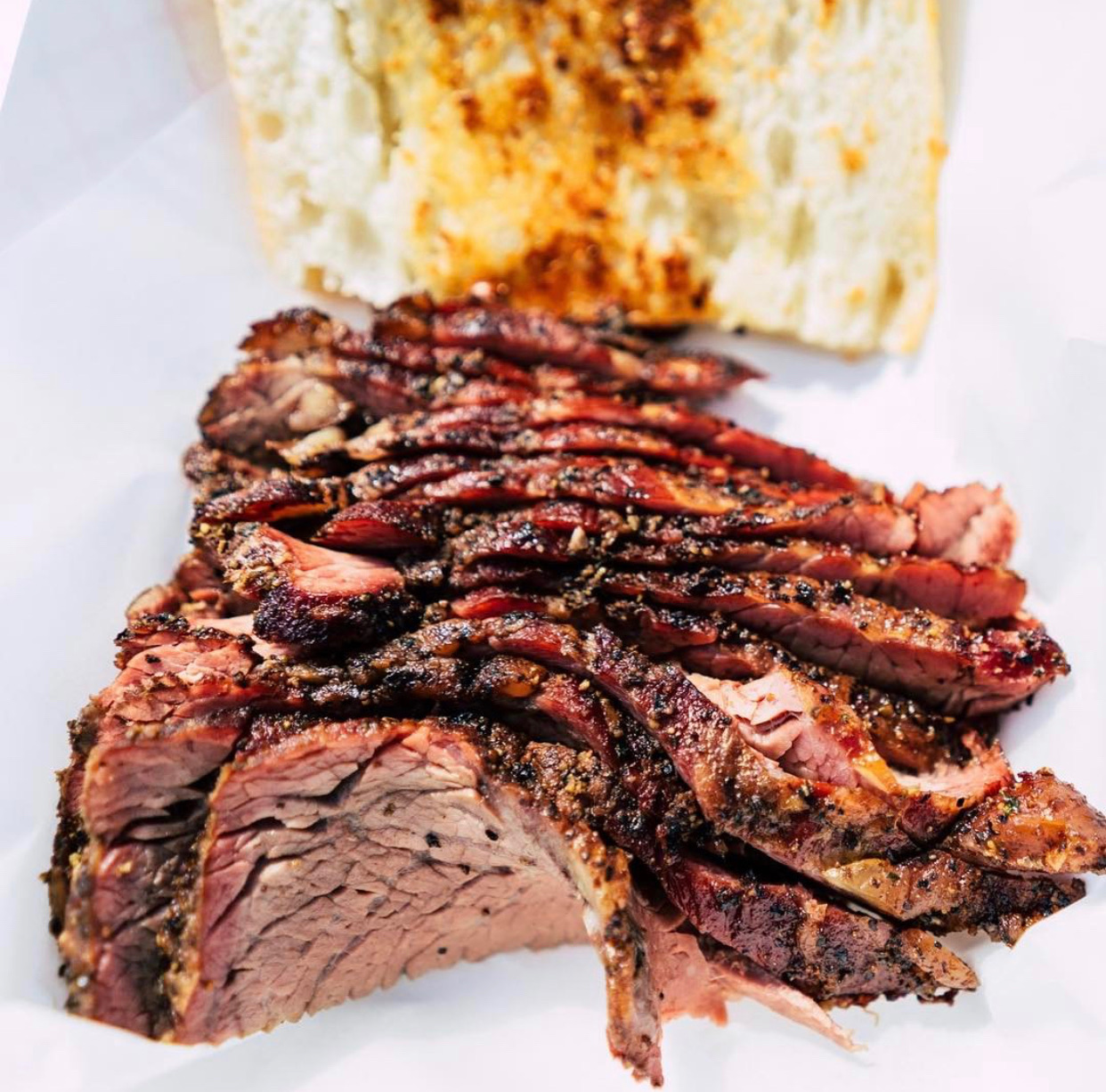 Sliced smoked tri-tip with garlic bread